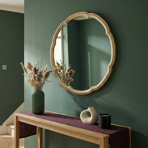Round scalloped wall mirror with ornate champagne gold frame and decorative beaded detailing